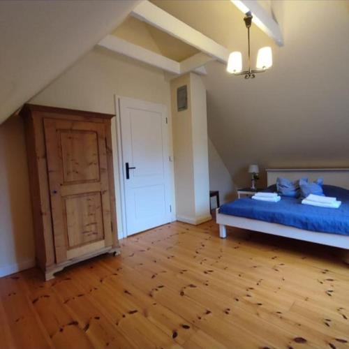 a bedroom with a blue bed and a wooden floor at Ferien in Troja in Lärz