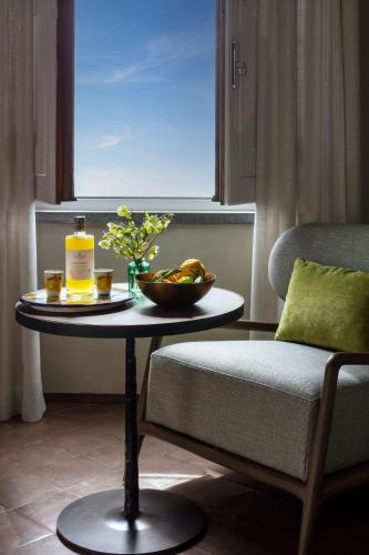 a table with a bottle of oil and a bowl of fruit at Anantara Convento di Amalfi Grand Hotel in Amalfi