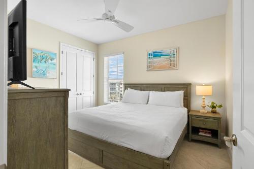 Un dormitorio con una cama blanca y un televisor. en One Particular Harbour 395-402, en Burnt Store Marina