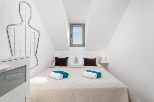 una camera bianca con un letto con due cuscini di Esperia a Opatija