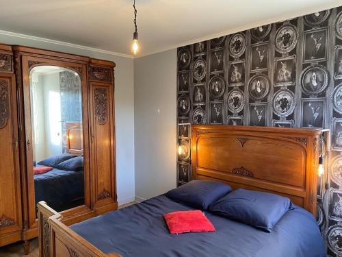 - une chambre avec un lit et un mur avec des assiettes dans l'établissement Schönes Ferienhaus in Strandnähe in Privatresidenz Alouettes & Moineaux in der Nahe Mont St Michel, à Hauteville-sur-Mer