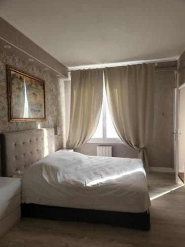 une chambre avec un lit blanc et une fenêtre dans l'établissement Proche centre ville, GIP ASFO, vue sur le jardin, à Grasse