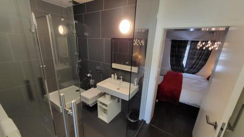a bathroom with a shower and a sink and a bed at Luxury Apt - View of the Center of Prague in Prague