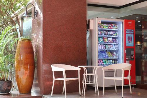 a drink station with two chairs and a drink cooler at Nonthaburi Palace Hotel in Nonthaburi