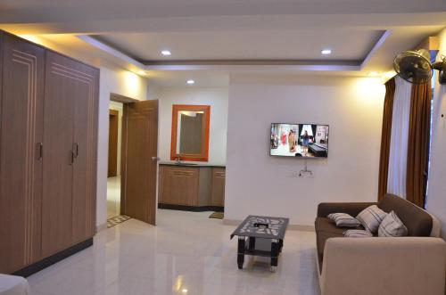 a living room with a couch and a table at Golden Grand by Xury Hotels in Tiruchchendūr