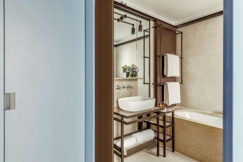 a bathroom with a tub and a sink and a bath tub at Tivoli Portopiccolo Sistiana Wellness Resort & Spa in Sistiana
