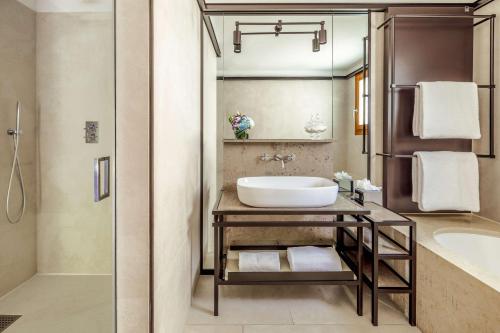 a bathroom with a sink and a shower and a tub at Tivoli Portopiccolo Sistiana Wellness Resort & Spa in Sistiana
