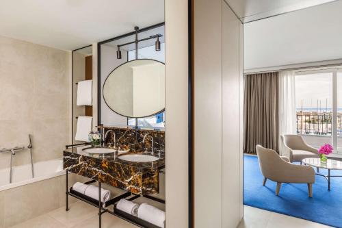 a bathroom with two sinks and a mirror at Tivoli Portopiccolo Sistiana Wellness Resort & Spa in Sistiana