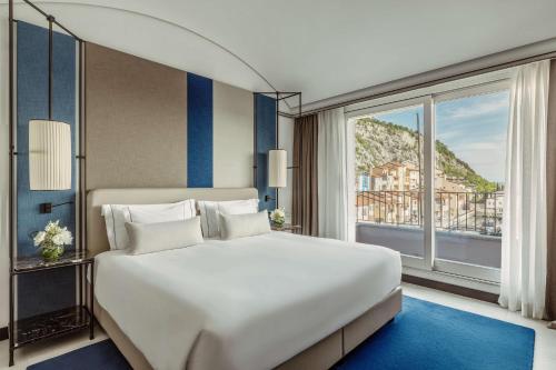 a bedroom with a large bed and a large window at Tivoli Portopiccolo Sistiana Wellness Resort & Spa in Sistiana