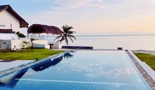 a swimming pool in front of the ocean at The White House Beach Apartments Koh Phangan in Ban Nua