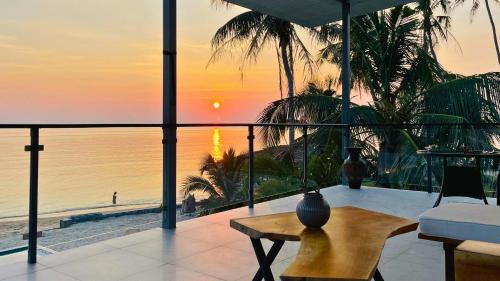 a room with a view of the beach and the sunset at The White House Beach Apartments Koh Phangan in Ban Nua