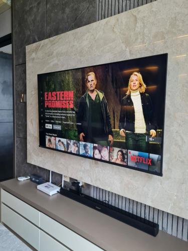 a flat screen tv sitting on top of a wall at Best View Designer Style Apartement Branz BSD 1BR in Samporo