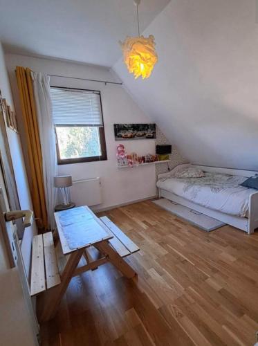 une chambre avec un lit et une table dedans dans l'établissement Jolie villa 700 m de la plage et des commerces, 120m2, 3 chambres, à Ouistreham