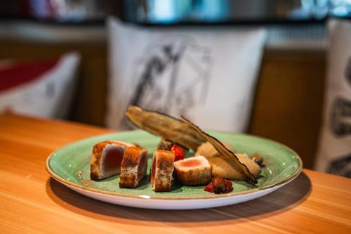 a green plate of food on a table at Altapura Hôtel & Spa Val Thorens in Val Thorens