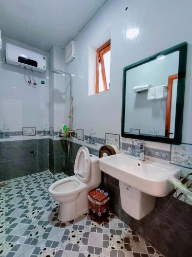 a bathroom with a sink and a toilet and a mirror at New Day Homestay in Ninh Binh