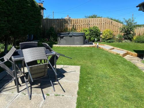 a patio with two chairs and a table in a yard at Little Dusty - Between St Agnes & Perranporth in St. Agnes