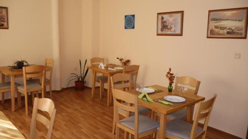 a dining room with wooden tables and chairs at Hotel Palitra in Varna City
