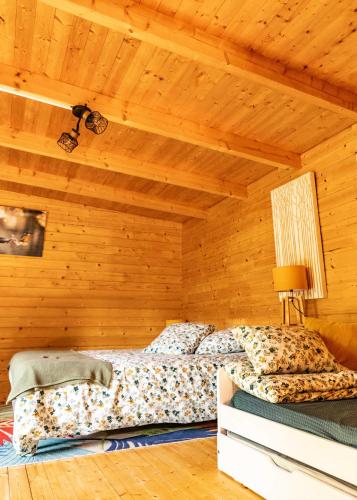 une chambre avec un lit dans une pièce en bois dans l'établissement Au fil de l'Ance, à Beauzac