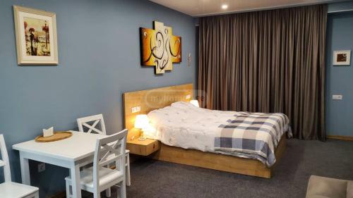 a bedroom with a bed and a table and a desk at New Gudauri GN Apartments in Atrium in Gudauri