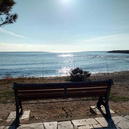 a bench sitting in front of the ocean at Villa Orsola in Villaputzu