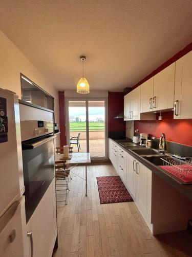 une cuisine avec des placards blancs et une salle à manger avec une table dans l'établissement Les Rives du Golf parking privé, à Seilh