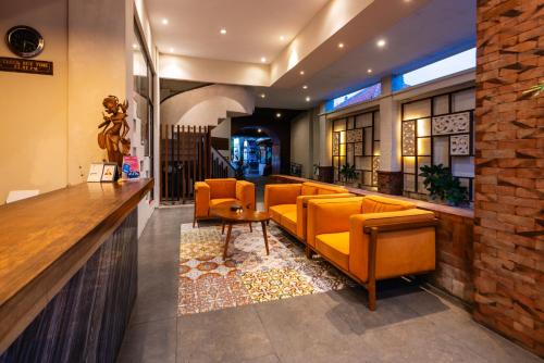 a lobby with orange chairs and a bar at Bali Ayu Hotel & Villas in Seminyak