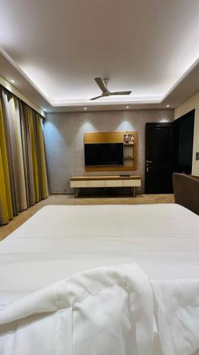 a bedroom with a large bed and a flat screen tv at Luxury HomeStay Prime Location, South Delhi in New Delhi