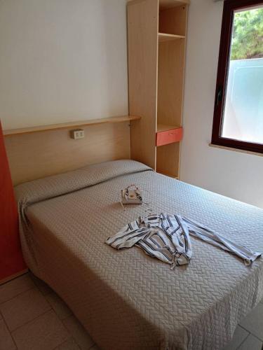 a bed with a pair of shoes sitting on it at Centro Vacanze Mirage in Torre di Palme