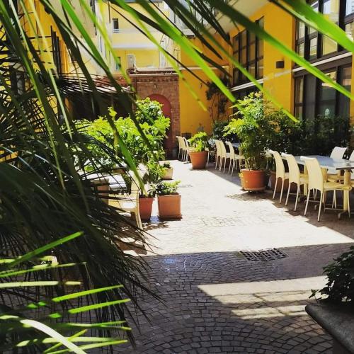 a courtyard with tables and chairs and plants at La Maison del Capestrano in Milan