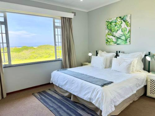 a bedroom with a large bed and a large window at St Lucia Holiday Cottage in St Lucia