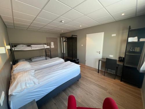 a bedroom with a bed and a desk with a chair at Vagnsstadir Guesthouse in Borgarhöfn