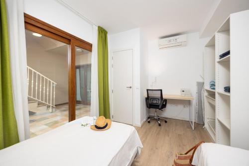 a room with a bed and a desk and a chair at Villa Mariposas Caleta in Caleta De Fuste