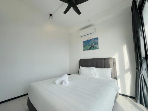 a bedroom with a bed with white sheets and a ceiling fan at 3B2R 2CarPark Tea Time Suite with Infinity Pool in Jelutong