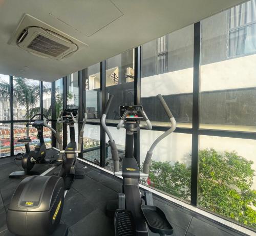 a row of exercise bikes in a gym with windows at 3B2R 2CarPark Tea Time Suite with Infinity Pool in Jelutong