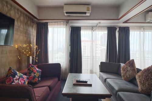 a living room with a couch and a table at Nonthaburi Palace Hotel in Nonthaburi