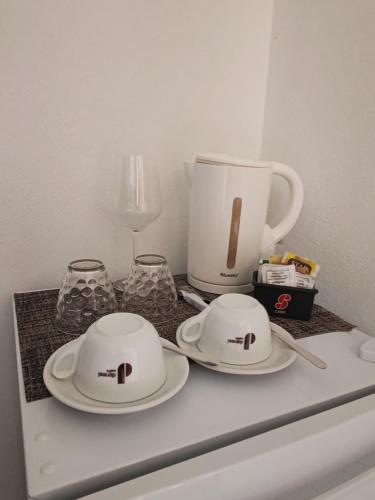 two white plates and glasses on top of a counter at Villa Orsola in Villaputzu