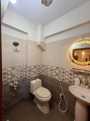 a bathroom with a toilet and a sink and a mirror at Two BR l DHA Phase 5 l Near Seaview l First Floor in Karachi
