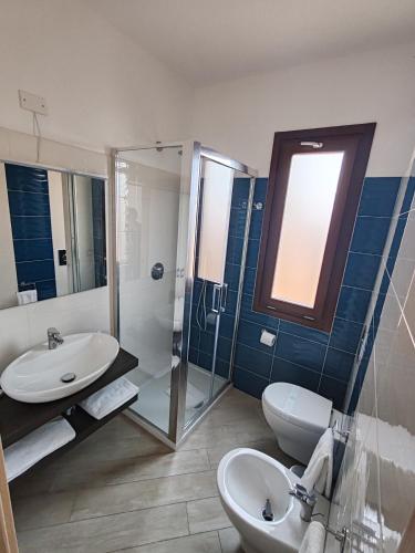 a bathroom with a sink and a toilet and a shower at Villa Orsola in Villaputzu