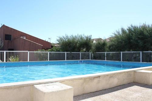une grande piscine entourée d'une clôture. dans l'établissement Maison 3 pièces mezzanine - GRUISSAN GN120-006, à Gruissan