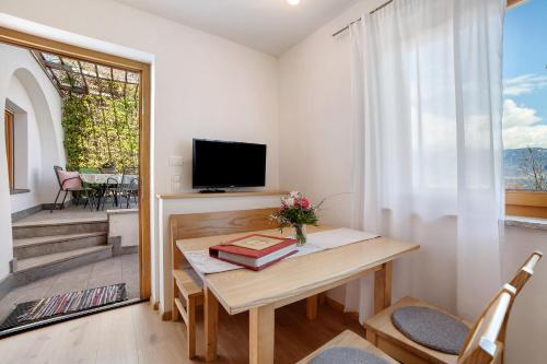 a small living room with a table and a television at Fröhlichhof Wohnung Pergola in Lagundo
