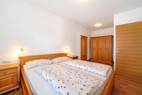 a bedroom with a large bed and wooden furniture at Fröhlichhof Wohnung Pergola in Lagundo