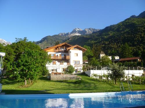 a house in the mountains next to a swimming pool at Fröhlichhof Wohnung Pergola in Lagundo