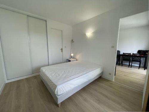 une chambre blanche avec un lit et une table dans l'établissement Appt 2 pièces LA ROCHELLE - LR020-205, à La Rochelle