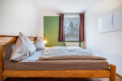 a bedroom with a wooden bed with a window at Kolbatzer Mühle in Lychen