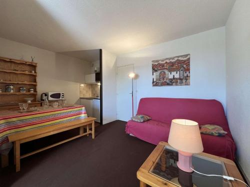 un salon avec un canapé rouge et une table dans l'établissement Appartement 2 pièces cabine - Gruissan GN130-820, à Gruissan