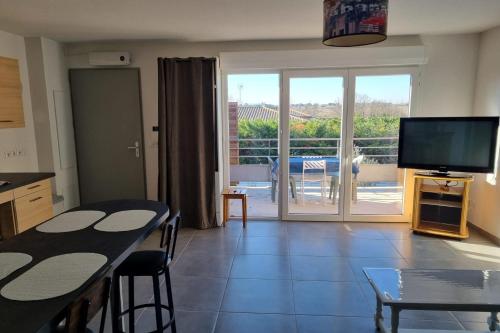 un salon avec une table à manger et une télévision dans l'établissement Appartment 2 Bedrooms 60m - 4 people - Marseillan City, à Marseillan