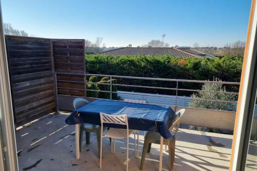 d'une table bleue et de chaises sur un balcon avec vue. dans l'établissement Appartment 2 Bedrooms 60m - 4 people - Marseillan City, à Marseillan