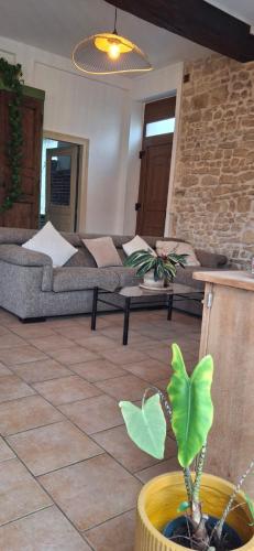 un salon avec un canapé et une plante en pot dans l'établissement charmante maison de ville avec cour privee a 1km du golf, à Villedieu-sur-Indre