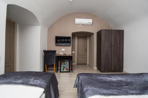 a hotel room with two beds and a desk at Passage Hotel in Baku