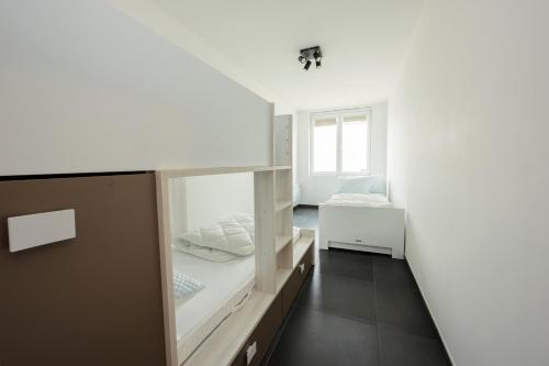 a white room with two beds and a window at Zeedijk 237 Middelkerke in Middelkerke